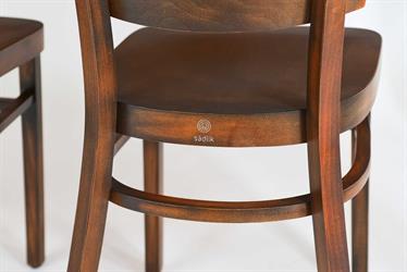 Dining chair Linetta, brand Sádlík, size M41 with a hole for a better grip 1G in the backrest, special wood stain color - Antique 18A, black. Detail of the bend of the leg joint with the Sádlík logo on the back of the seat veneer Czech furniture manufacturer, Sádlík